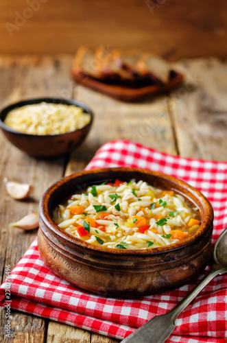 Turkey orzo vegetables soup with fresh rye bread slices