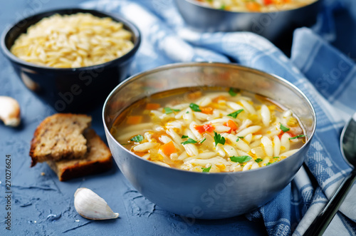 Turkey orzo vegetables soup with fresh rye bread slices