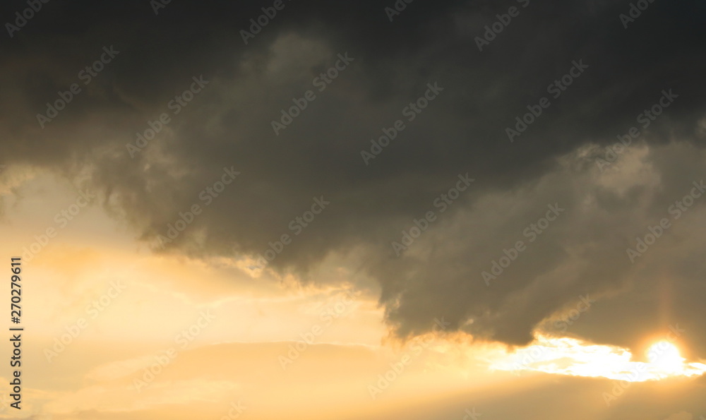 Dramatic dark clouds on orange sky background and texture