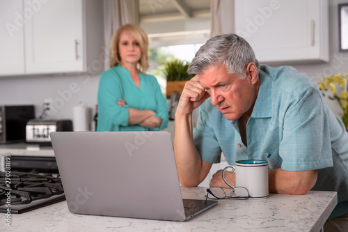 Senior couple stressed from receiving bad news in email, possibly health care, retirement funds, mortgage, or investments © elnariz