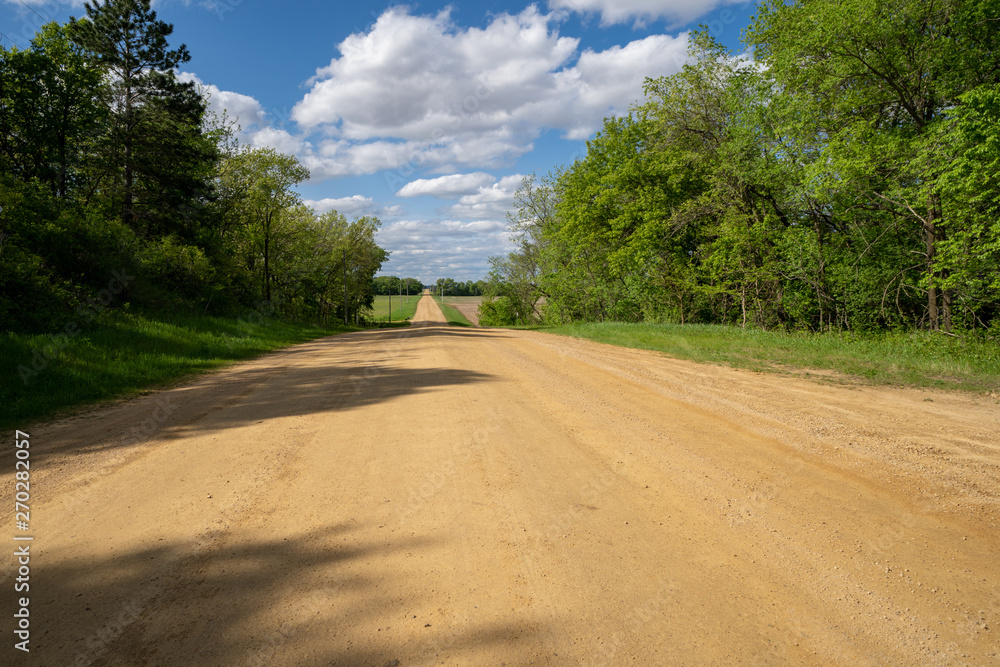 Empty, rural dirt unpaved road in Dakota County, Minnesota on a sunny spring day
