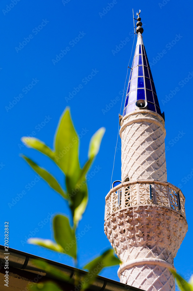 Φωτογραφία Sunlight from a blue sky shines through the glass top of a minaret of a mosque