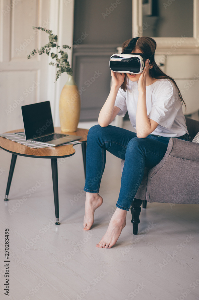 Young female programmer testing a new app with virtual reality glasses in home Young female programmer testing a new app with virtual reality glasses in home