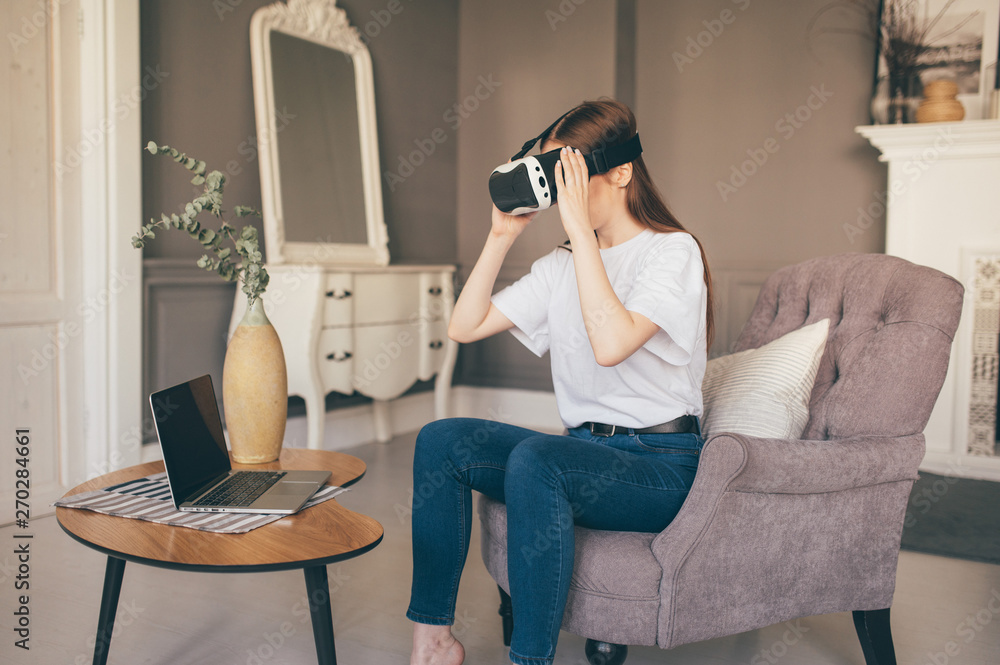 Young female programmer testing a new app with virtual reality glasses in home Young female programmer testing a new app with virtual reality glasses in home