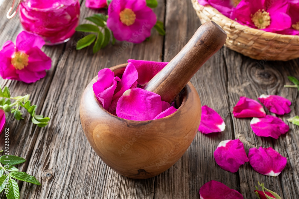 Fresh rosa rugosa petals in a wooden mortar Fresh rosa rugosa petals in a wooden mortar