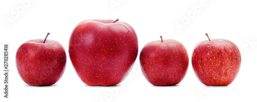 Four different sized fresh apples isolated on white background. Three red small apples and one larger apple in a row.