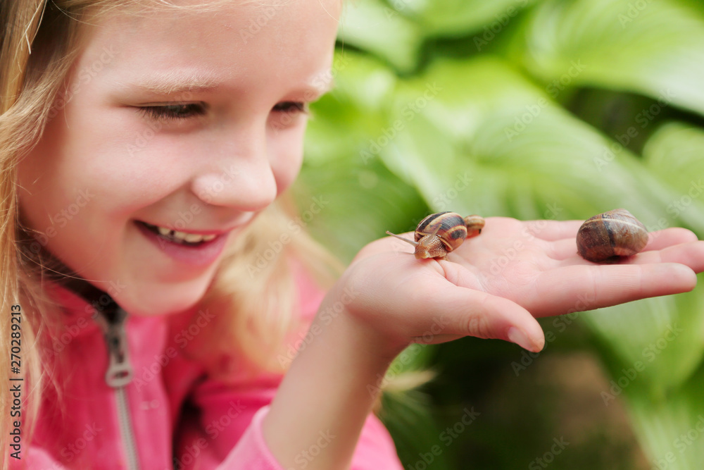Obraz premium little girl holding snails on her hand