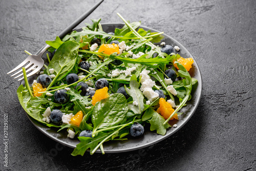 Summer salad with salad leaves, fruits, berries and cheese