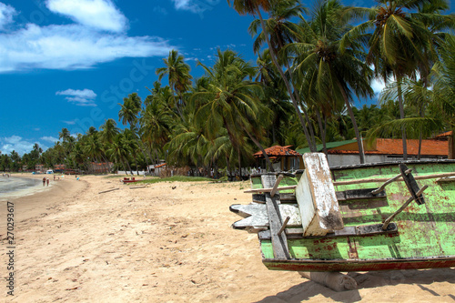 Praia Brasileira  com barco de pescador nativo  mostrando coqueiros e mar.