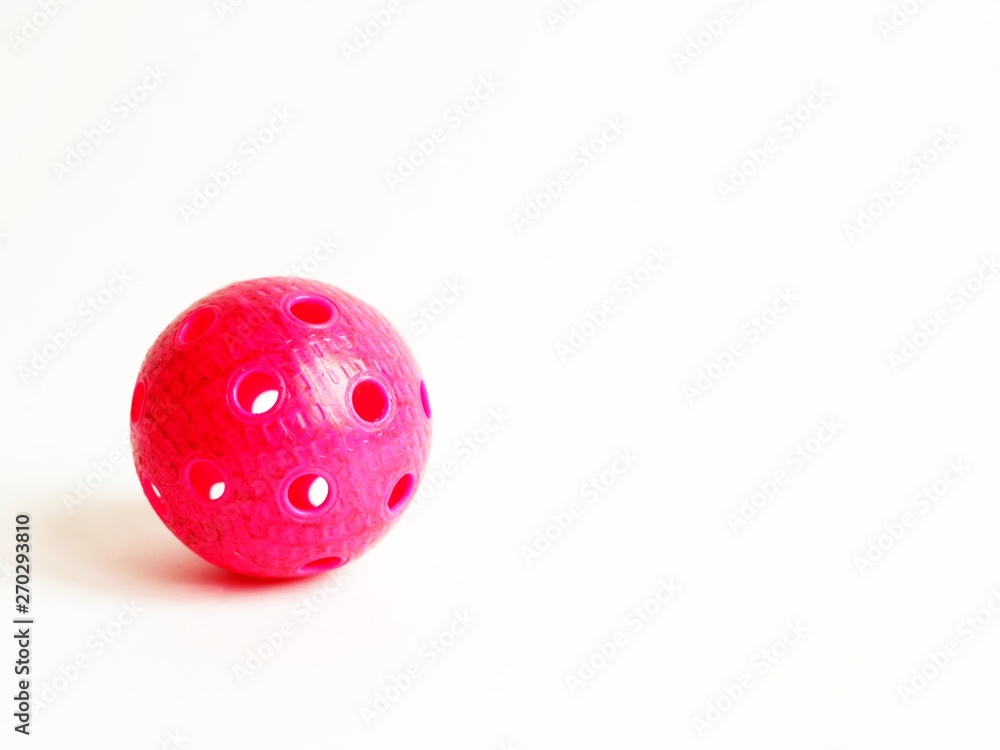 physical education and sport concept. sports games. red floorball ball on white background. copy space for text. physical education and sport concept. sports games. red floorball ball on white background. copy space for text.