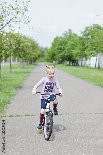 Fototapeta Naklejka Na Ścianę i Meble -  Beautiful blonde young girl riding a white vintage bicycle