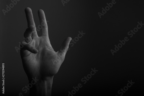 Male open hand gesture on a dark background