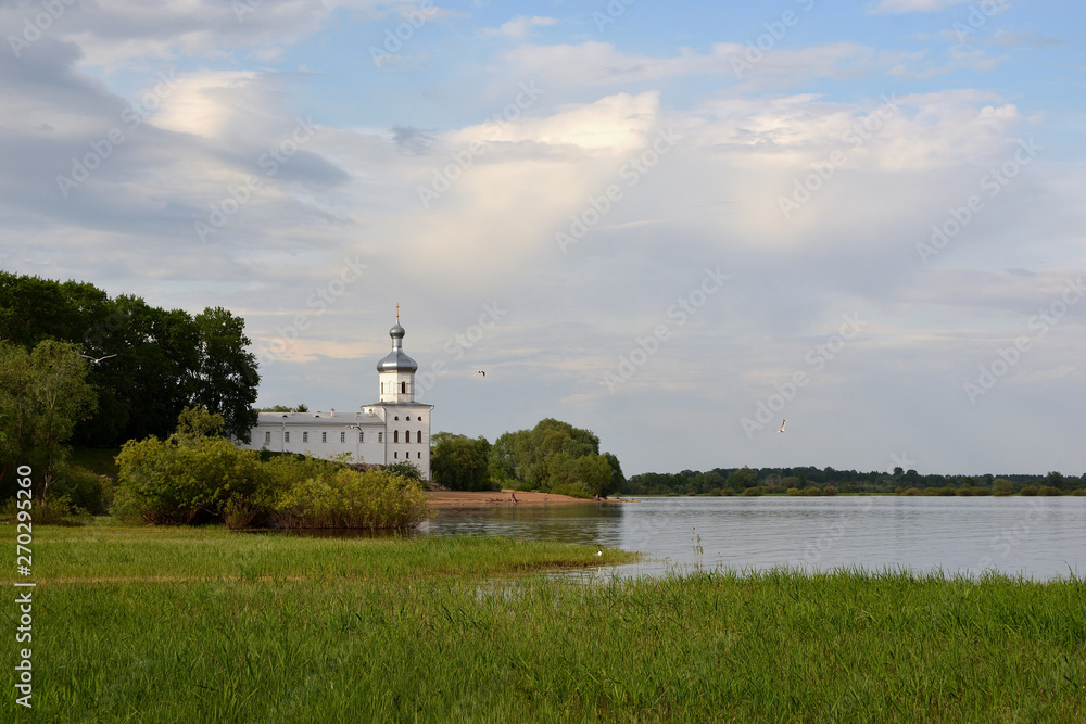 Church of St. Michael the Archangel in the Yurievsky Monastery Veliky Novgorod. Beautiful summer view with a river and a church and a cloudy sky