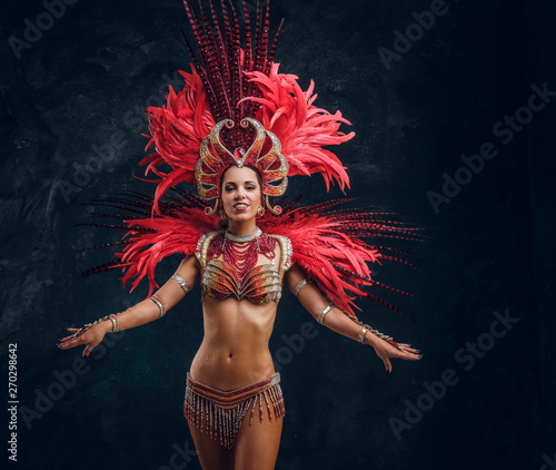 Fotografiet Happy beautiful brasil dancer in red feather costume is dancing on small scene