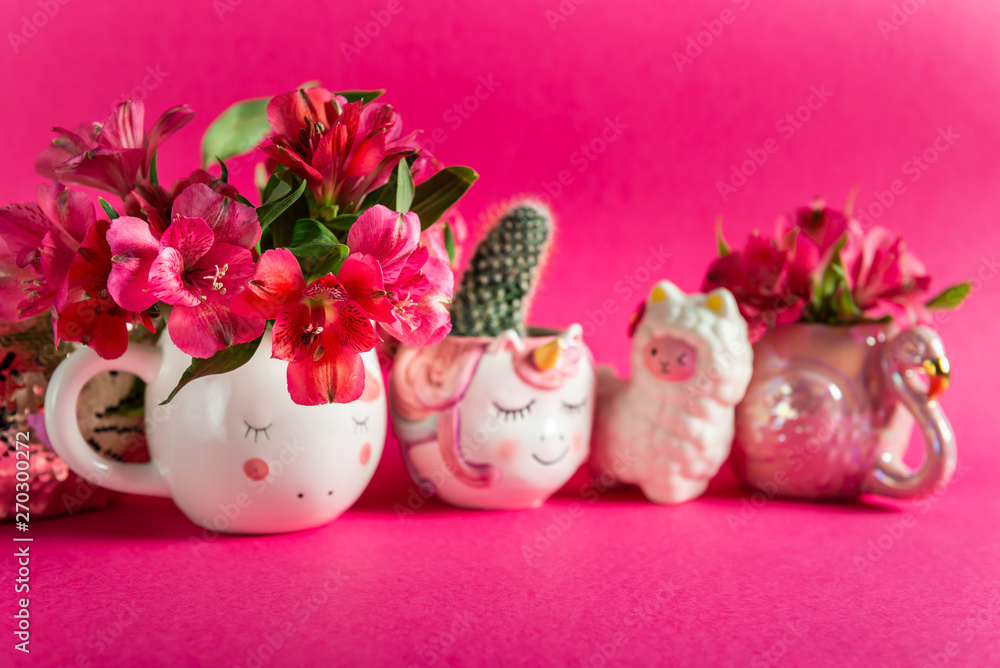 Unicorn mugs and Flamingo mug with Alstroemeria on bright pink background. Idea of Girly settings. Vivid postcard for any holidays Unicorn mugs and Flamingo mug with Alstroemeria on bright pink background. Idea of Girly settings. Vivid postcard for any holidays
