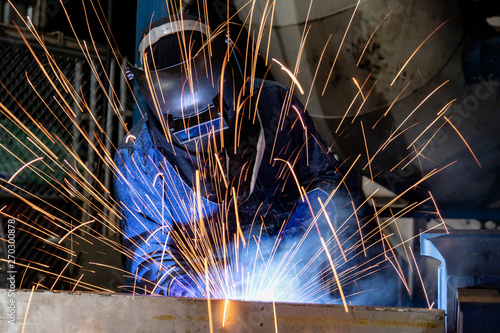 Worker is welding in factory