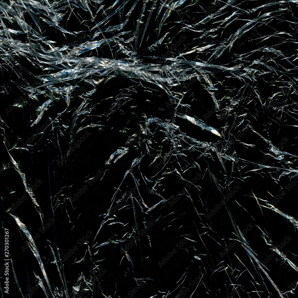Transparent plastic wrap on the black background. Plastic bag texture. Reusable trash and waste. Transparent plastic wrap on the black background. Plastic bag texture. Reusable trash and waste.
