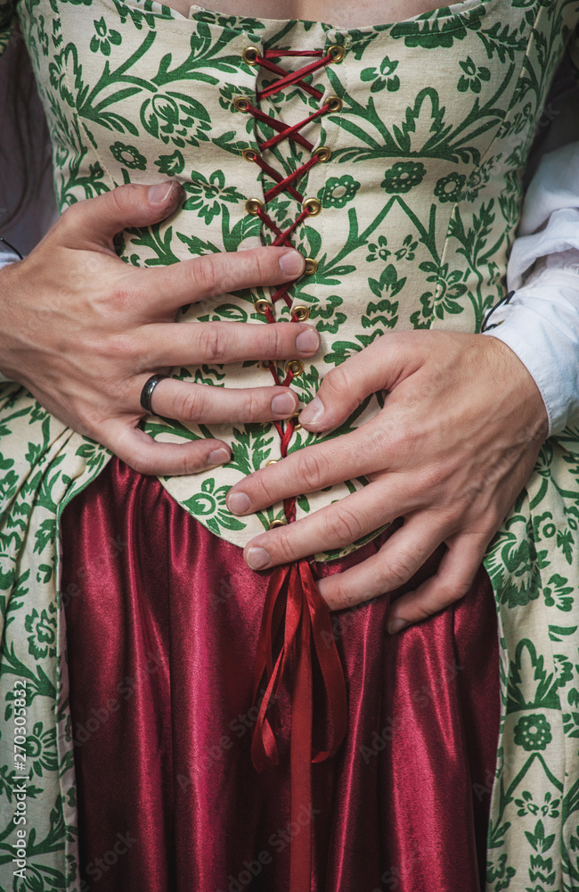 Mans hands holding woman in medieval dress