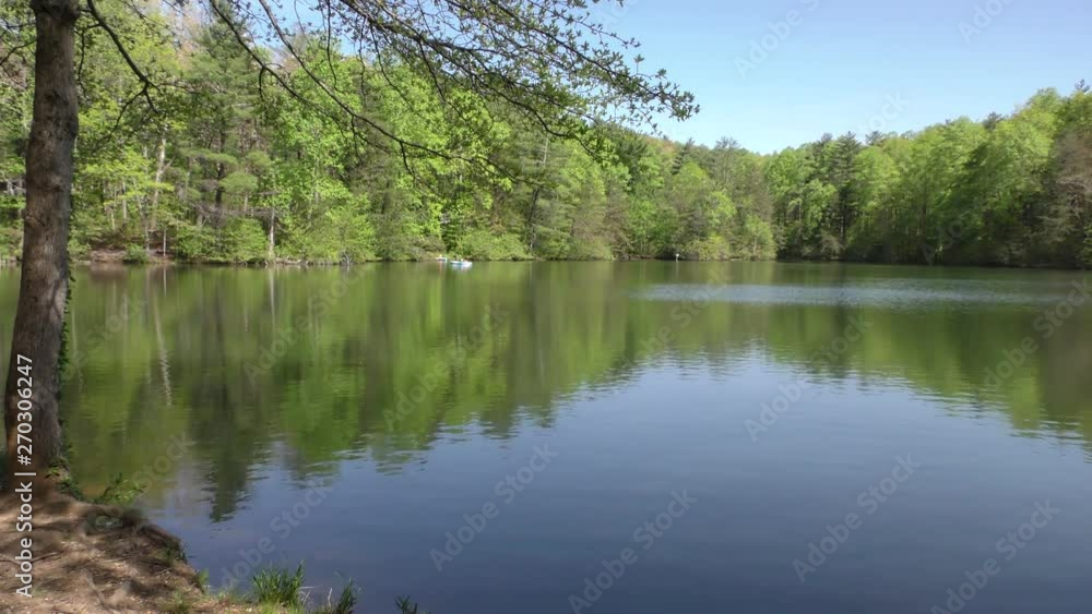 Fort Mountain, Lake with reflections trees and a canoe in the distance Fort Mountain, Lake with reflections trees and a canoe in the distance