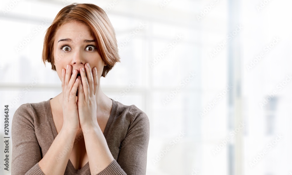 Worried woman holding face with hands on background Worried woman holding face with hands on background