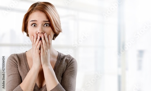Worried woman holding face with hands on background