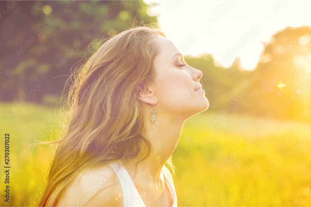 Young woman on field under sunset light Young woman on field under sunset light