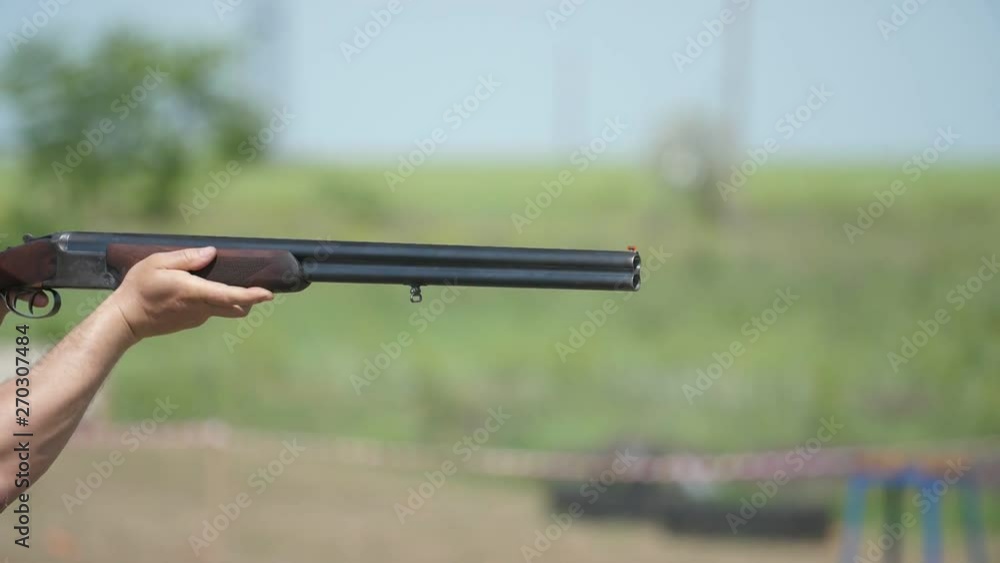 Hunting over and under gun shooting clay targets on a big range in slo-mo Hunting over and under gun shooting clay targets on a big range in slo-mo