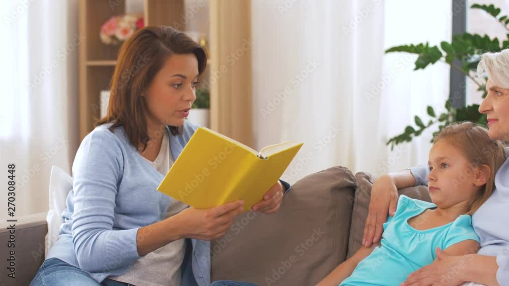 family and three generations concept - happy mother, daughter and grandmother reading book at home family and three generations concept - happy mother, daughter and grandmother reading book at home
