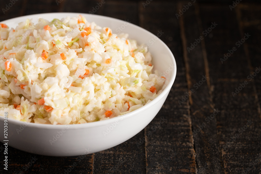 Bowl of Coleslaw on a Rustic Wooden Table Bowl of Coleslaw on a Rustic Wooden Table