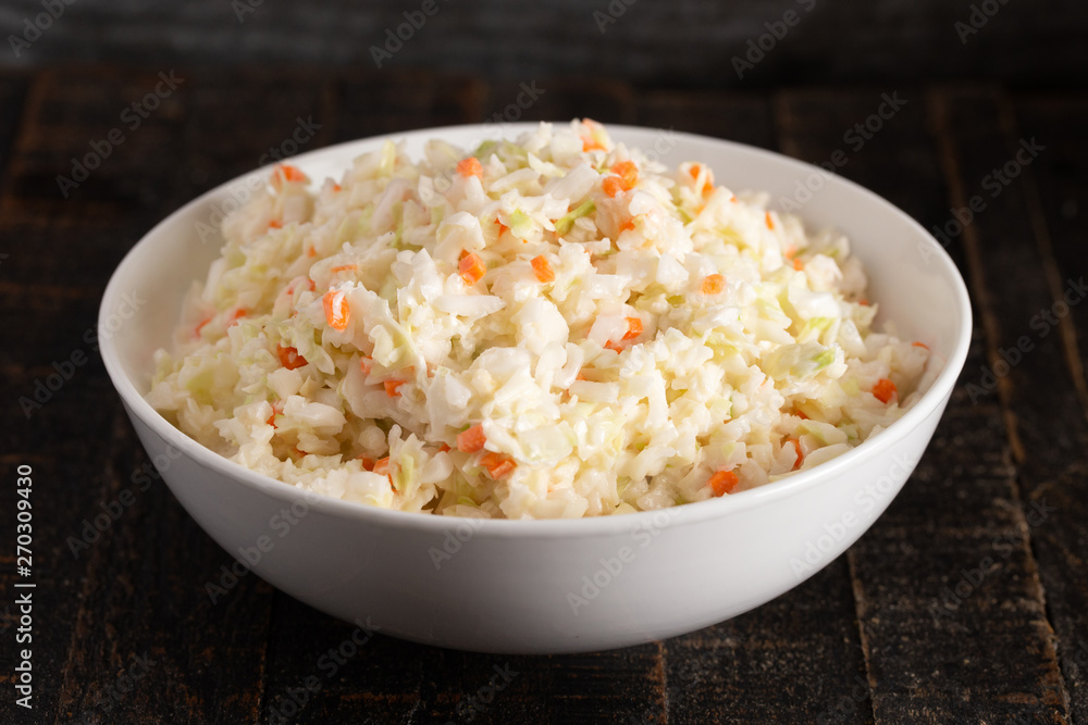 Bowl of Coleslaw on a Rustic Wooden Table Bowl of Coleslaw on a Rustic Wooden Table