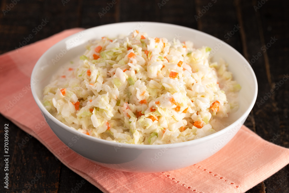 Bowl of Coleslaw on a Distressed Wooden Table Bowl of Coleslaw on a Distressed Wooden Table