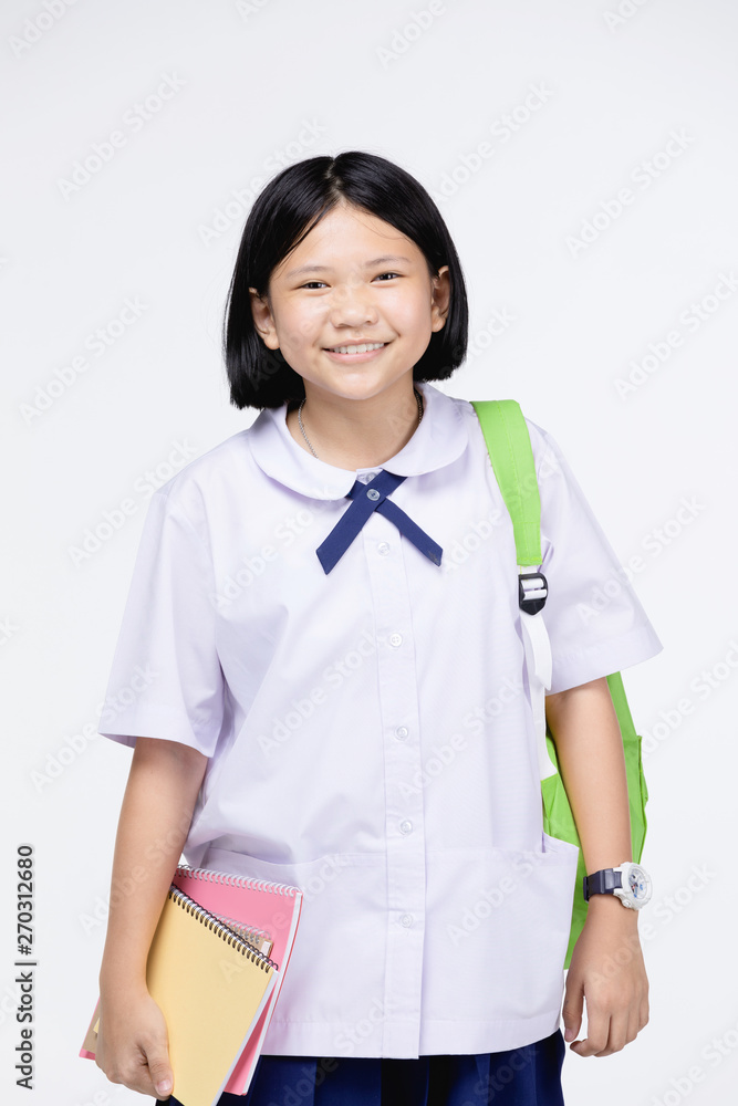 Cute girl in student's uniform with stationery on gray background. Cute girl in student's uniform with stationery on gray background.
