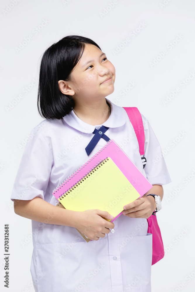 Cute girl in student's uniform with stationery on gray background. Cute girl in student's uniform with stationery on gray background.