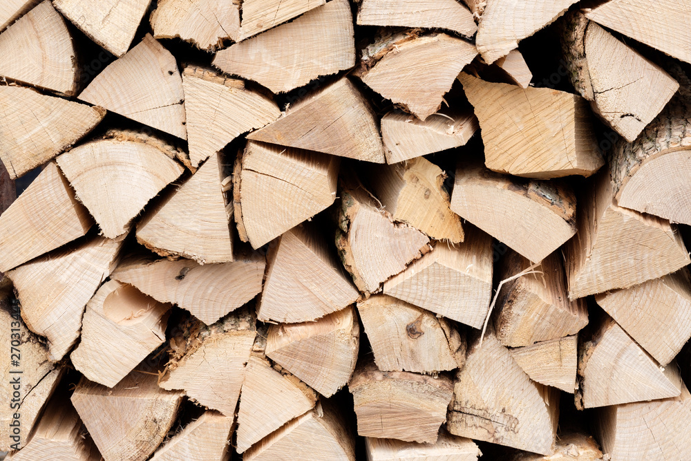 Wall of stacked firewood cut logs as background Wall of stacked firewood cut logs as background