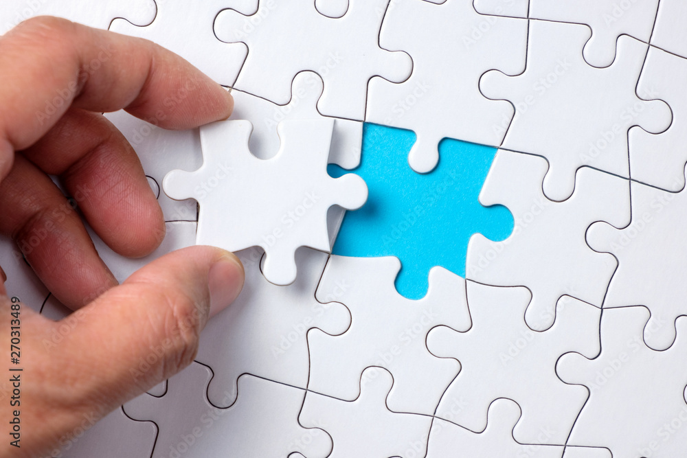 Hand placing the last jigsaw puzzle piece or holding missing jigsaw puzzle  piece down in to the place Stock Photo | Adobe Stock