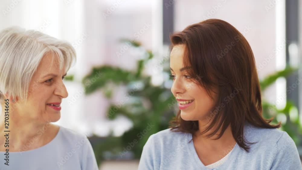 family, generation and people concept - happy smiling senior mother talking to adult daughter at home family, generation and people concept - happy smiling senior mother talking to adult daughter at home
