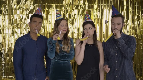 Boring! a group of people of mixed race standing on a golden background and bored. People at the party are not happy. Confetti falls. 4K