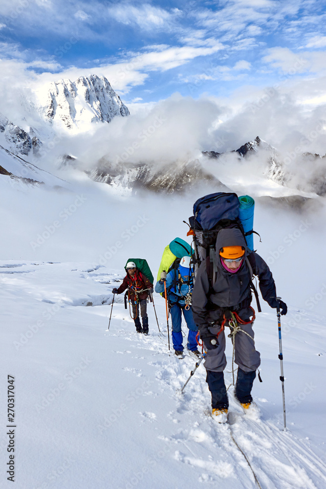 Bunch of mountaineers climbs to the top of a snow-capped mountain Bunch of mountaineers climbs to the top of a snow-capped mountain