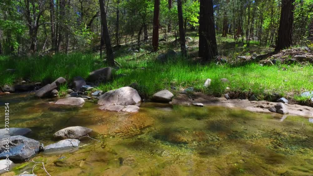 Clear mountain stream slowly flowing as large boulders you can see under the water. Clear mountain stream slowly flowing as large boulders you can see under the water.