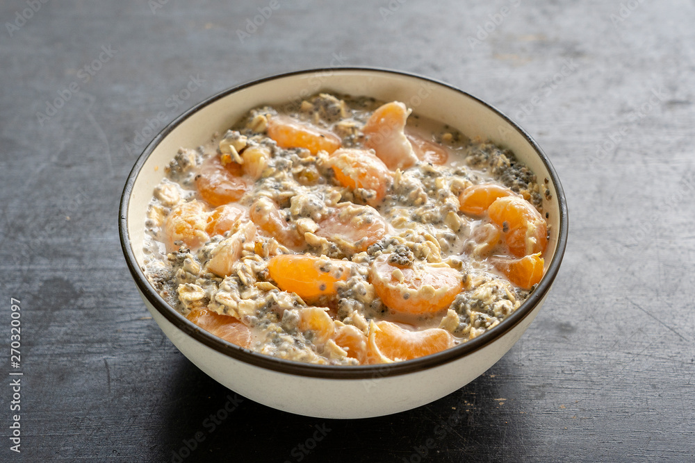 Muesli and yogurt with banana, mandarin, chia seeds and oat cereals, healthy food concept, close up Muesli and yogurt with banana, mandarin, chia seeds and oat cereals, healthy food concept, close up