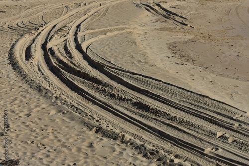 Four wheel drive tyre marks in soft sand background