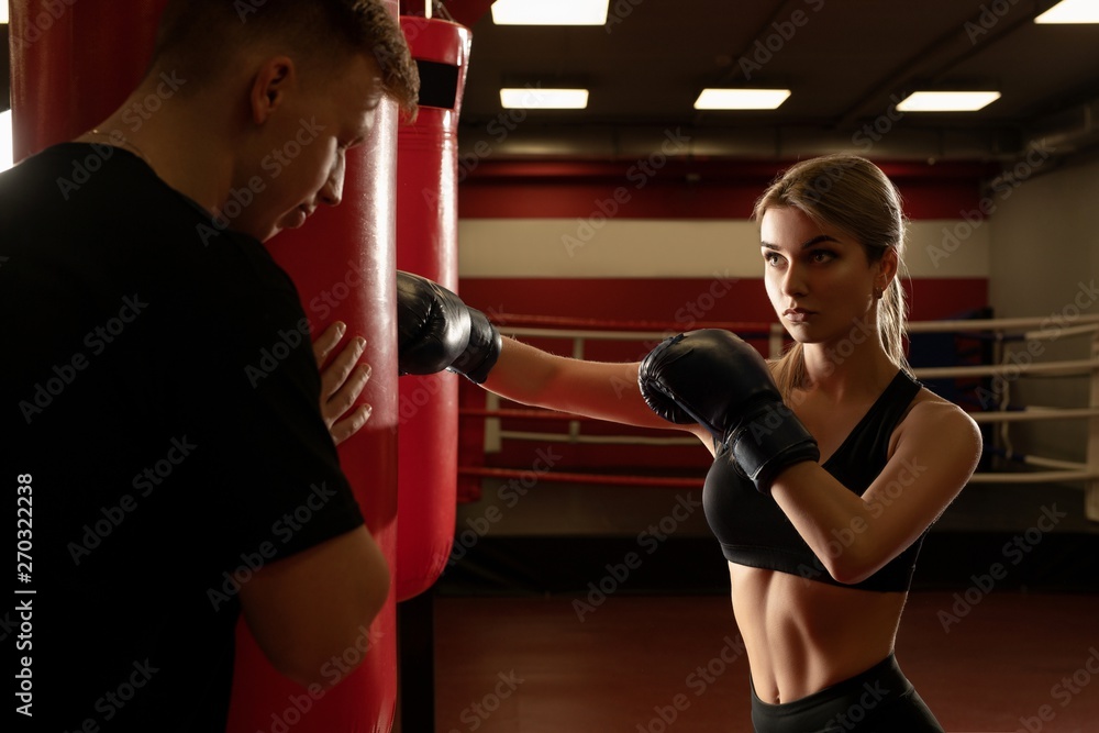 Fototapeta Boxer working out with trainer in gym