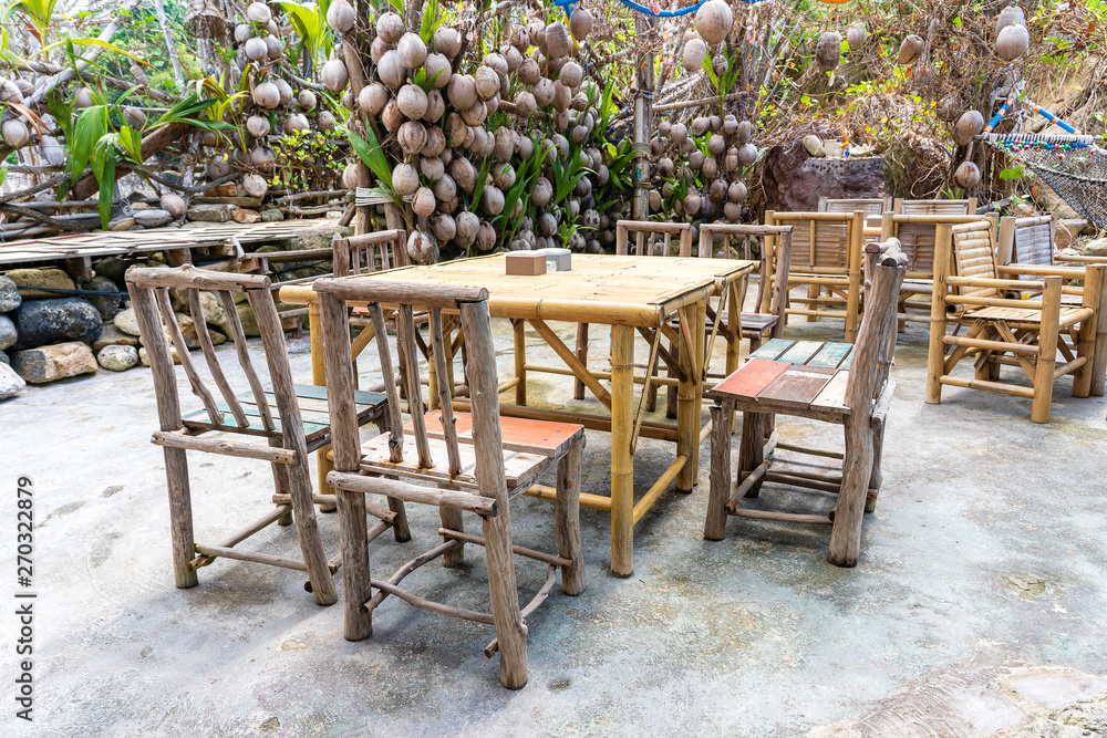 Wooden table and chairs in empty beach cafe next to sea. Island Koh Phangan, Thailand
