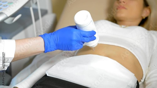 Doctor puts medical gel. A close up the hand of the doctor Taking A Sonogram a stomach the woman photo