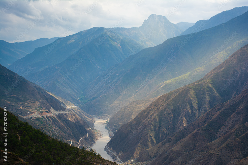 Landscape Scenery on the road between Lijiang and Shangri-La, Yunnan Province China. High Altitude Mountains, small village, Tibetan culture. Bright Blue Sky, natural Chinese landscape. China Travel