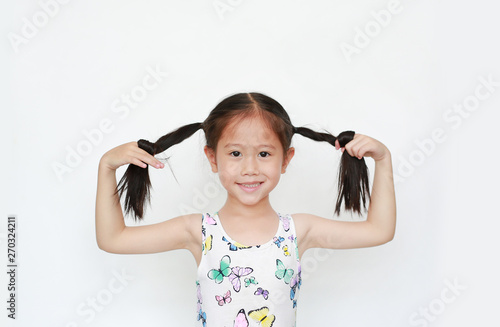 Happy of little Asian child girl holding pigtail on white background. Portrait smiling kid with two pigtails.