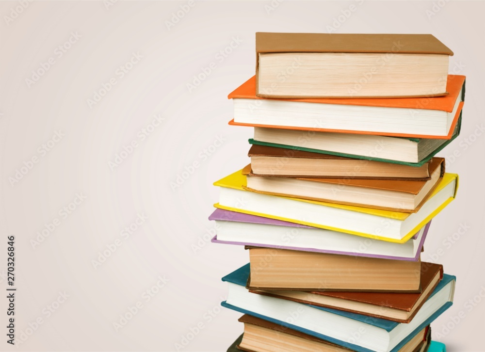 Collection of old books vertical stack on beige background Collection of old books vertical stack on beige background