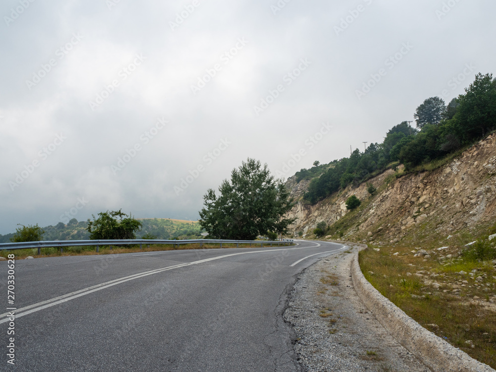 Mountain road goes on the top of the hills among the clouds from the coast inland Greece