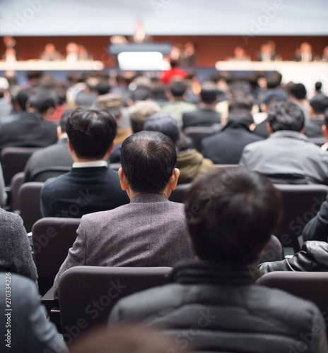 Old and young audience people attend conference in auditorium. Corporate seminar participants in development workshop. Executive manager giving speech at symposium. Business training at lecture hall. photo