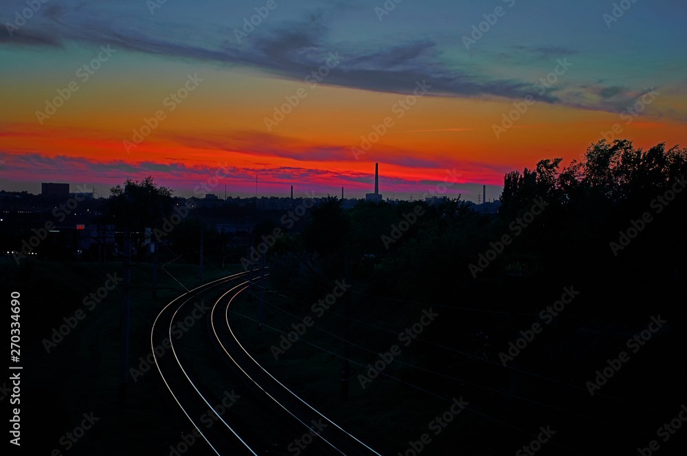 Railroad leaving into the distance on a background of red sunset